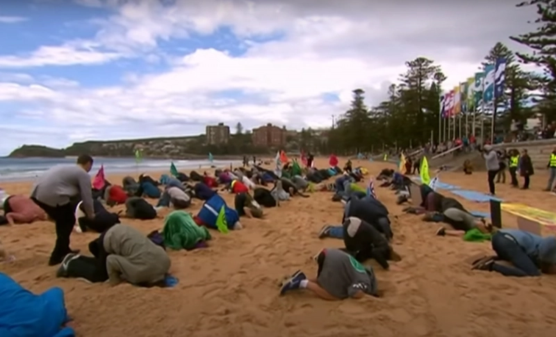 False: A viral video of people burying their heads in the sand is from a protest organized by Greta Thunberg to reduce CO2 emissions.