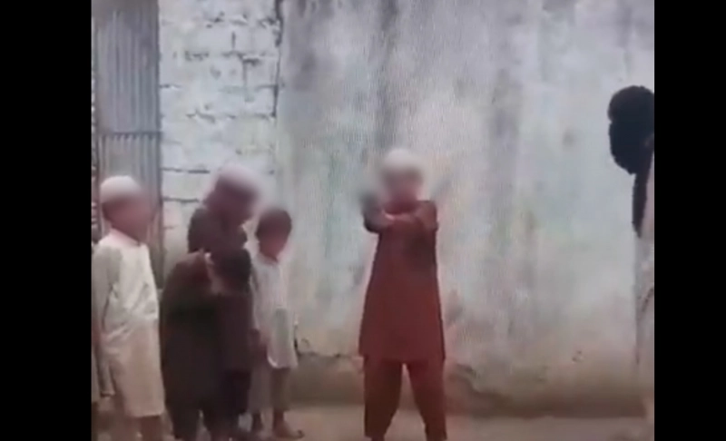 False: A video shows children being trained to shoot in a madrasa.