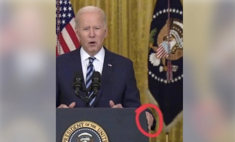 False: An image shows Biden placing a third hand on the podium during a press conference.